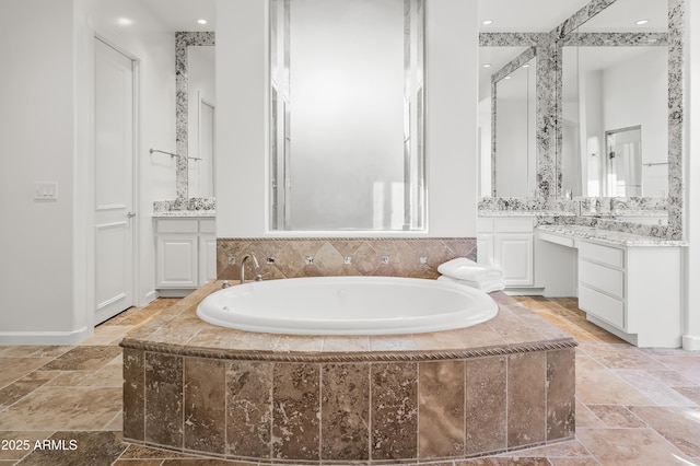 full bathroom featuring a garden tub, stone tile floors, and two vanities