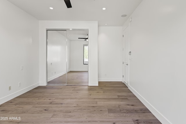 unfurnished bedroom with recessed lighting, wood finished floors, and baseboards