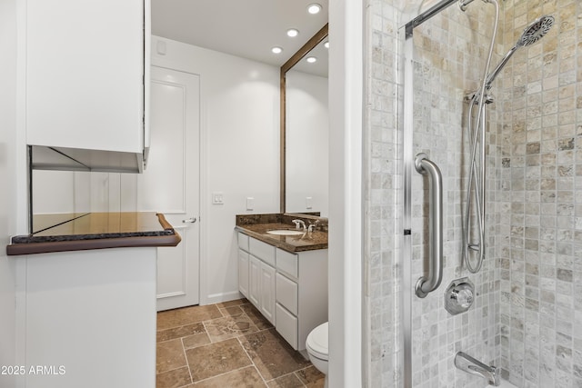 bathroom with toilet, stone tile flooring, a tile shower, recessed lighting, and vanity