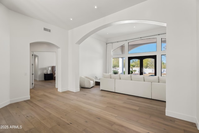 unfurnished living room featuring hardwood / wood-style floors, recessed lighting, visible vents, and baseboards