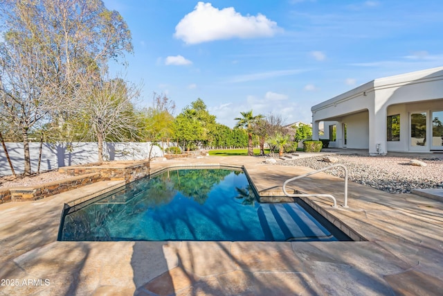 pool featuring fence and a patio area