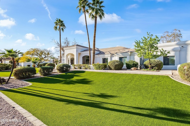 exterior space featuring stucco siding and a front yard