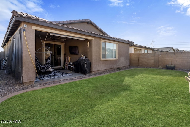 back of house featuring a yard and ceiling fan