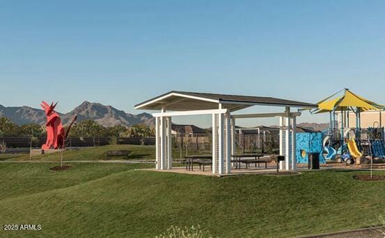 view of jungle gym featuring a mountain view and a lawn