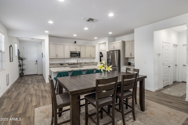 dining space with sink and hardwood / wood-style flooring