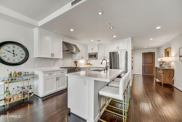 6803 E Main St Unit 5506, Scottsdale, AZ 85251 - kitchen featuring stainless steel appliances, wall chimney range hood, dark wood-style flooring, white cabinets, and light countertops