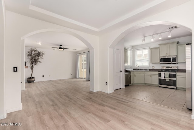 1162 S Agnes Ln, Gilbert, AZ 85296 - kitchen featuring stainless steel appliances, ceiling fan, dark countertops, open floor plan, and light wood-style floors