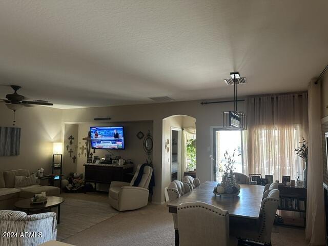 dining space featuring carpet, a textured ceiling, and ceiling fan