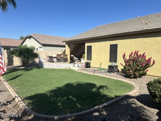 rear view of house featuring a patio area and a lawn