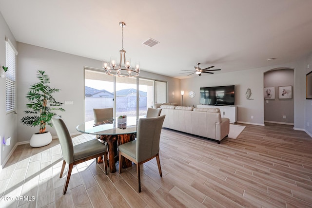 dining area featuring wood tiled floor, visible vents, arched walkways, and baseboards