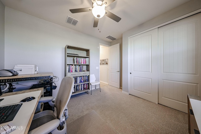 carpeted office space featuring baseboards, visible vents, and a ceiling fan