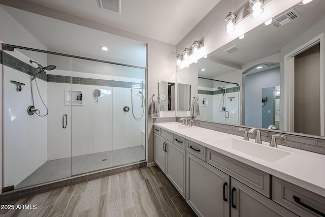 full bath with a stall shower, a sink, and visible vents