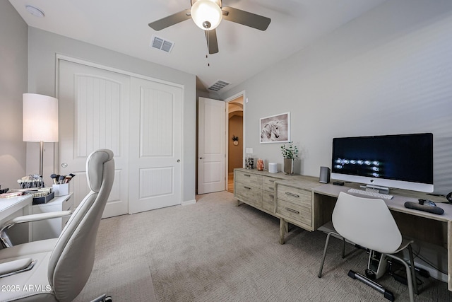 office space with a ceiling fan, arched walkways, visible vents, and light carpet