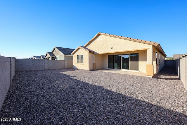 back of property featuring a patio, a tile roof, a fenced backyard, and stucco siding