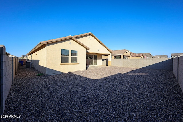 rear view of house featuring a tile roof, a fenced backyard, a patio, and stucco siding