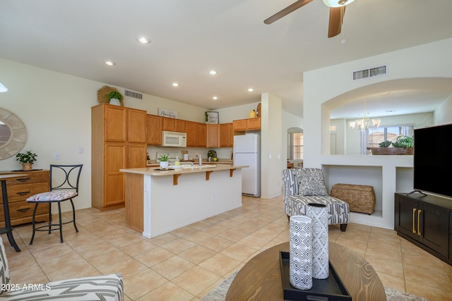 17640 W Babbitt Dr, Surprise, AZ 85374 - kitchen with white appliances, a breakfast bar, visible vents, light countertops, and arched walkways