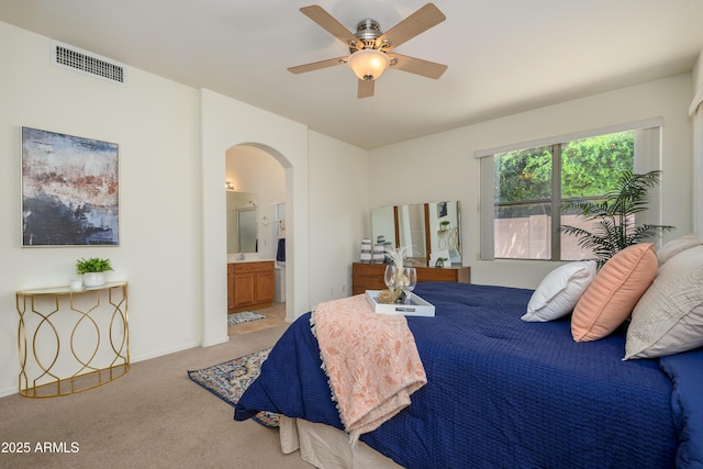 17640 W Babbitt Dr, Surprise, AZ 85374 - carpeted bedroom with arched walkways, visible vents, a ceiling fan, and connected bathroom