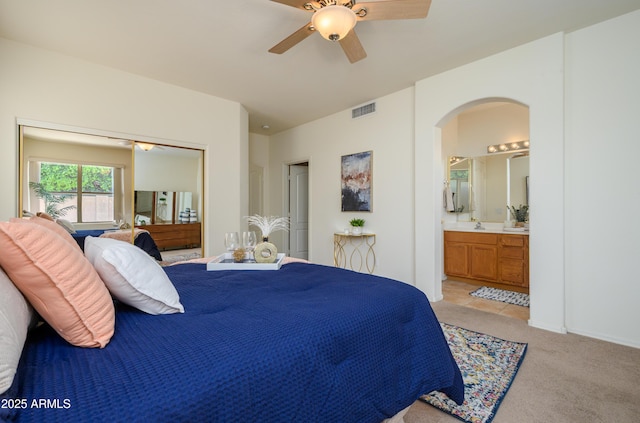 17640 W Babbitt Dr, Surprise, AZ 85374 - bedroom featuring arched walkways, connected bathroom, light carpet, a sink, and visible vents