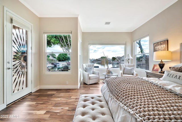 bedroom with wood-type flooring, a water view, and ornamental molding