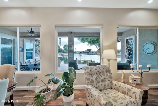 sitting room featuring a water view and wood-type flooring