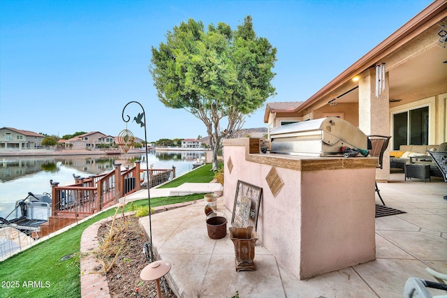 view of patio / terrace featuring area for grilling, grilling area, and a water view