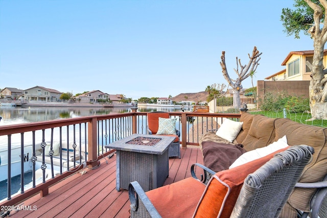 wooden deck featuring a fire pit and a water view