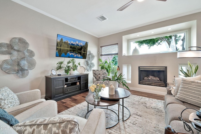 living room featuring crown molding, ceiling fan, and light hardwood / wood-style flooring