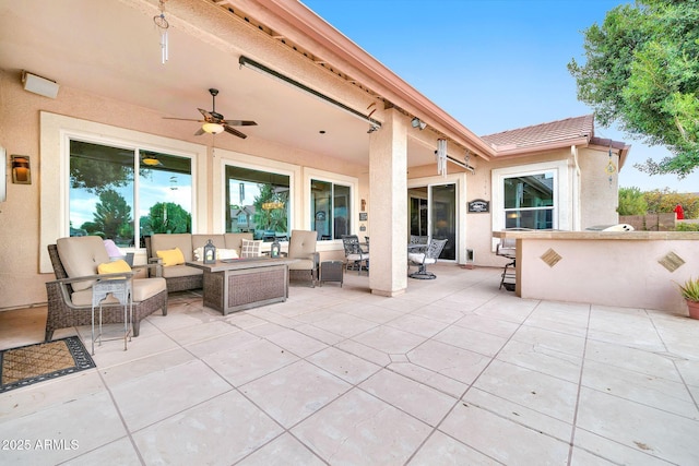 view of patio featuring ceiling fan, an outdoor living space, and exterior bar