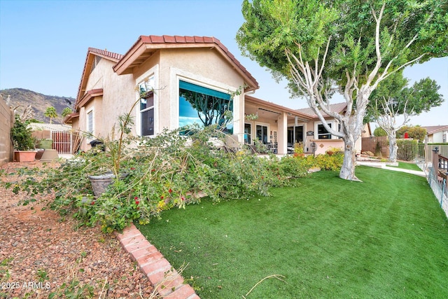 back of house featuring a yard and a mountain view