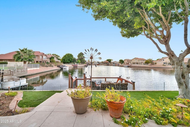 dock area featuring a lawn and a water view