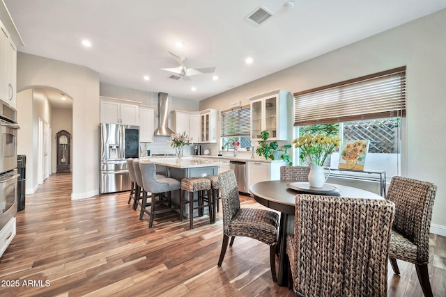 dining space with ceiling fan and light wood-type flooring