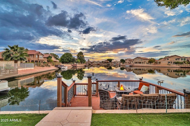 dock area with a water view and an outdoor fire pit