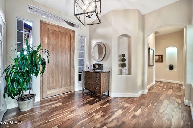 foyer entrance featuring an inviting chandelier and dark hardwood / wood-style floors