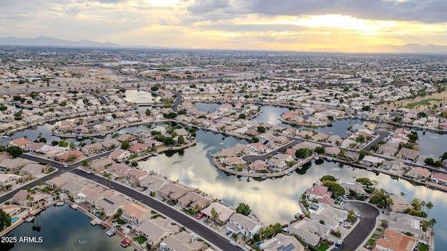 aerial view at dusk featuring a water view