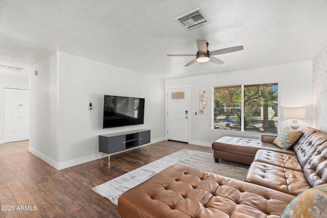 living room with ceiling fan, a textured ceiling, and dark hardwood / wood-style flooring