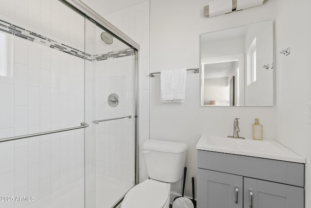 bathroom with vanity, a shower with shower door, and toilet