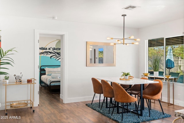 dining room featuring dark hardwood / wood-style floors and an inviting chandelier