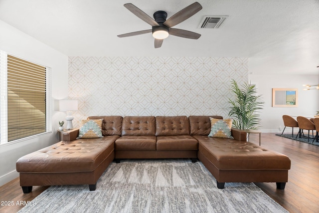 living room featuring ceiling fan with notable chandelier and wood-type flooring