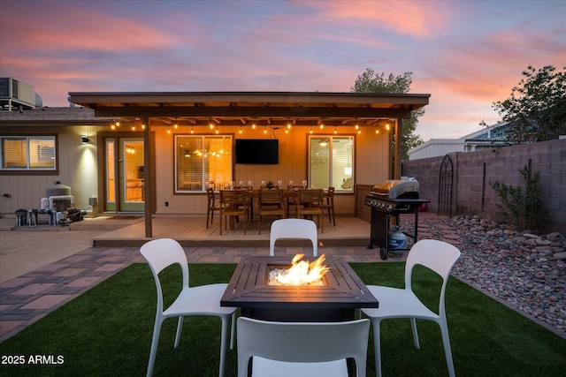 rear view of house with central AC, an outdoor fire pit, and a patio