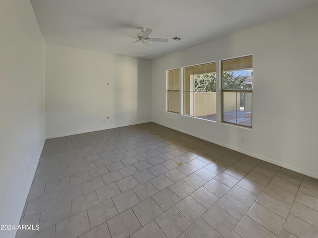 tiled spare room featuring ceiling fan