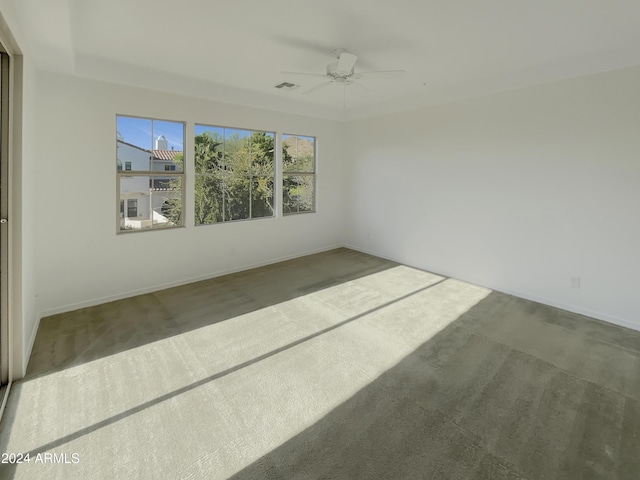 carpeted spare room featuring ceiling fan