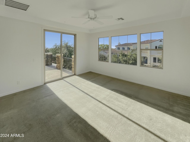 carpeted spare room featuring ceiling fan