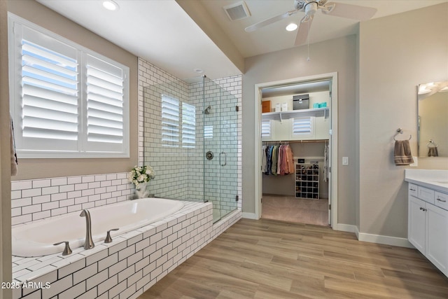 full bathroom with vanity, visible vents, a shower stall, a ceiling fan, and a garden tub