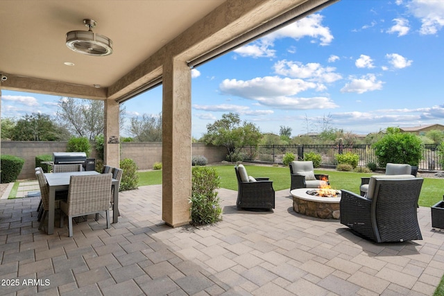view of patio / terrace with an outdoor fire pit, outdoor dining space, and a fenced backyard