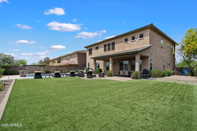 rear view of house featuring a fenced backyard, a patio area, stucco siding, and a yard