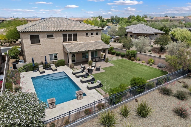 back of property with a tiled roof, stucco siding, a lawn, a fenced backyard, and a patio area