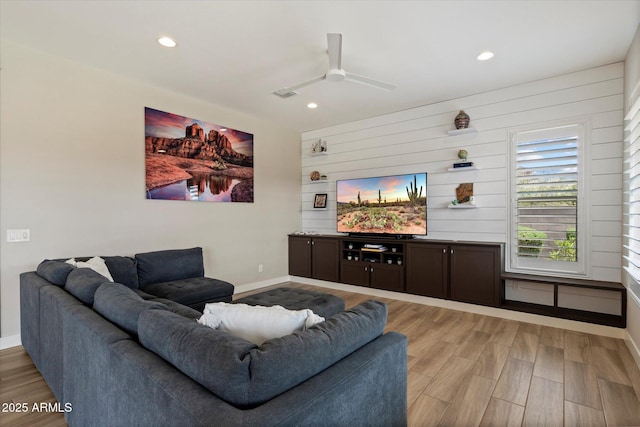 living room featuring baseboards, a ceiling fan, and recessed lighting