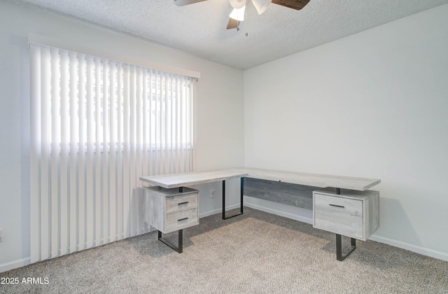 carpeted home office featuring a textured ceiling and ceiling fan