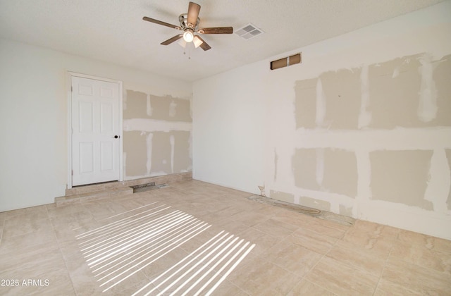 spare room featuring a textured ceiling and ceiling fan