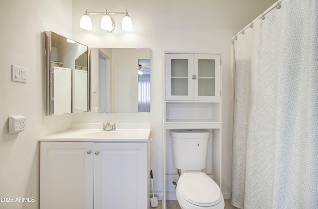 bathroom with toilet, vanity, and ceiling fan